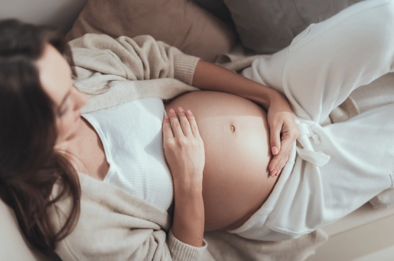 Pregnant woman resting and holding her belly